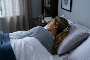 Ontspannen vrouw die vredig slaapt op een satijnen kussen, met een rustige, gehydrateerde huid