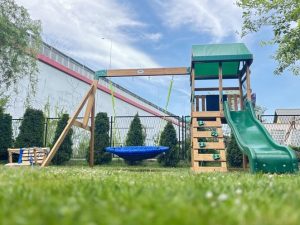 Houten speeltoestel met wiegtoren in de tuin van Garden Way