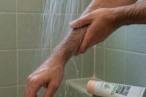 Handen spoelen zweet af onder douche na zonnebank